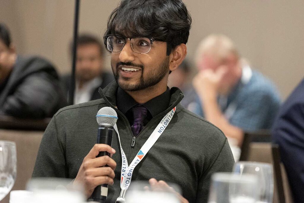 Man attending NVTC event holding a microphone to speak