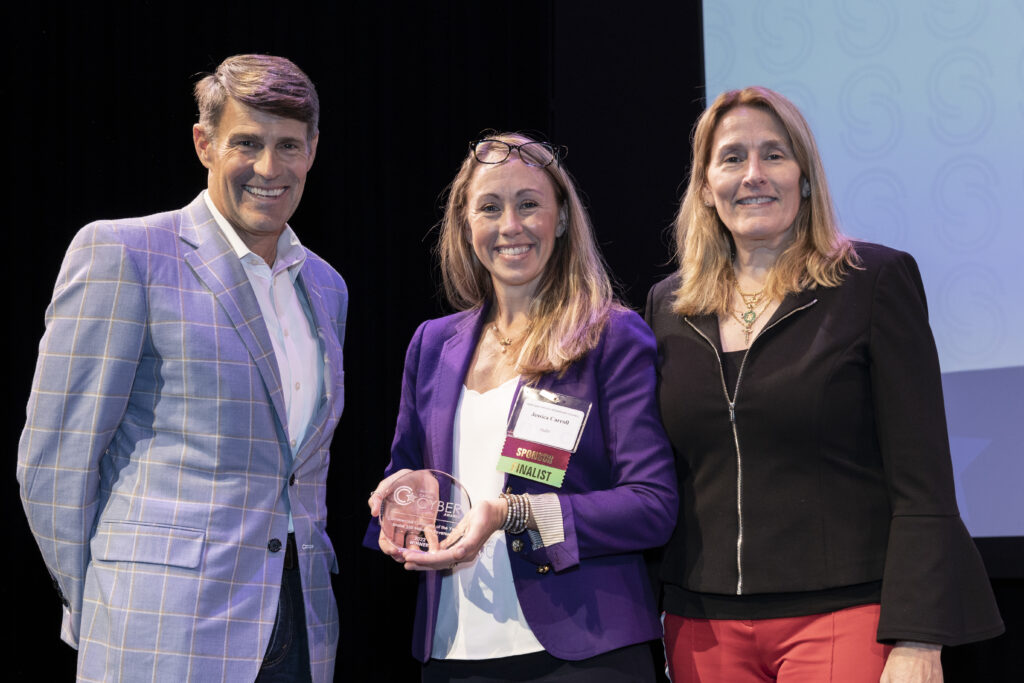 Woman holding Cyber award with man and woman on either side of her