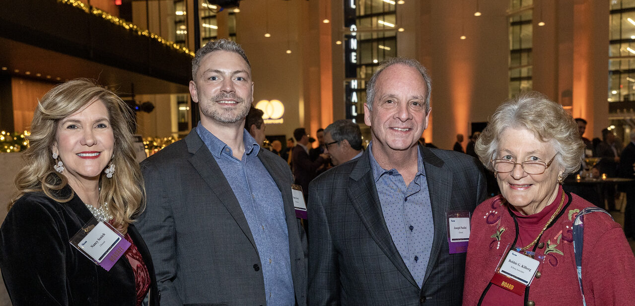 A group of two men flanked by two women celebrating Tech 100