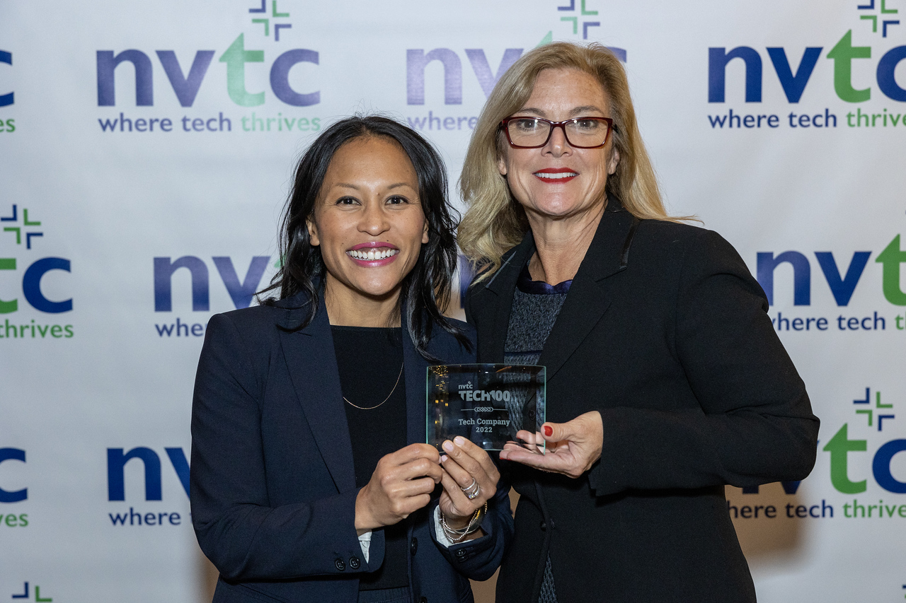 Two women holding Tech 100 awards