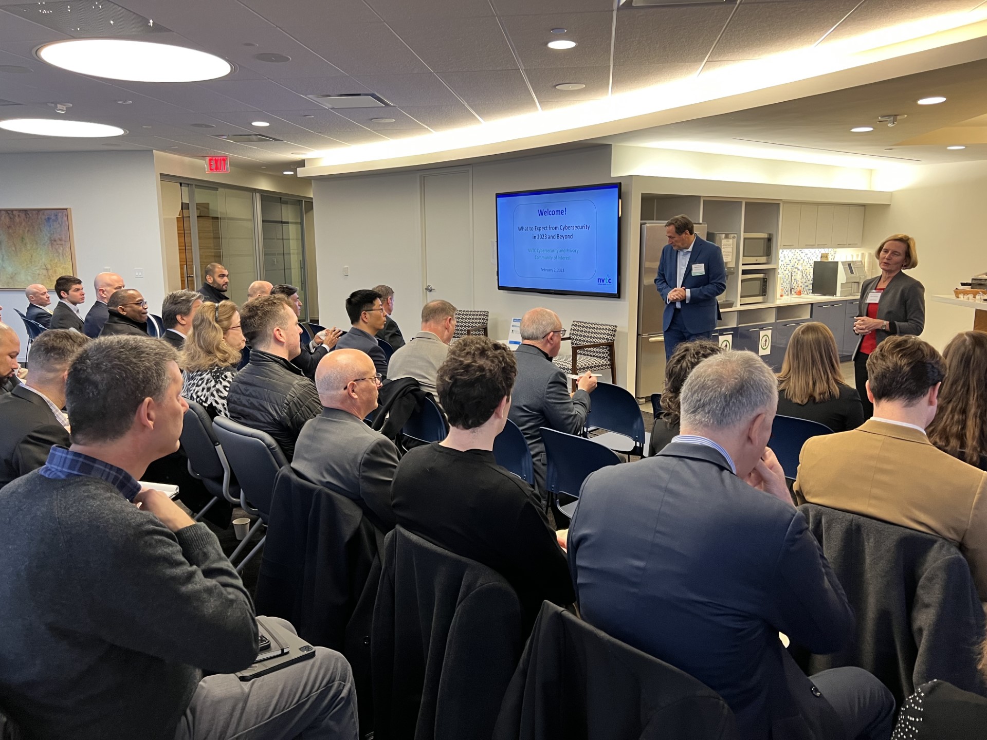 Group of people in a room during a presentation for the Cybersecurity COI meeting.